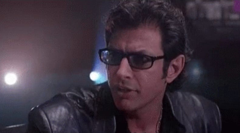 A screenshot of Jeff Goldblum's character Dr. Ian Malcolm in Jurassic Park, about to say his iconic line, "Your scientists were so preoccupied with whether or not they could that they didn't stop to think if they should."